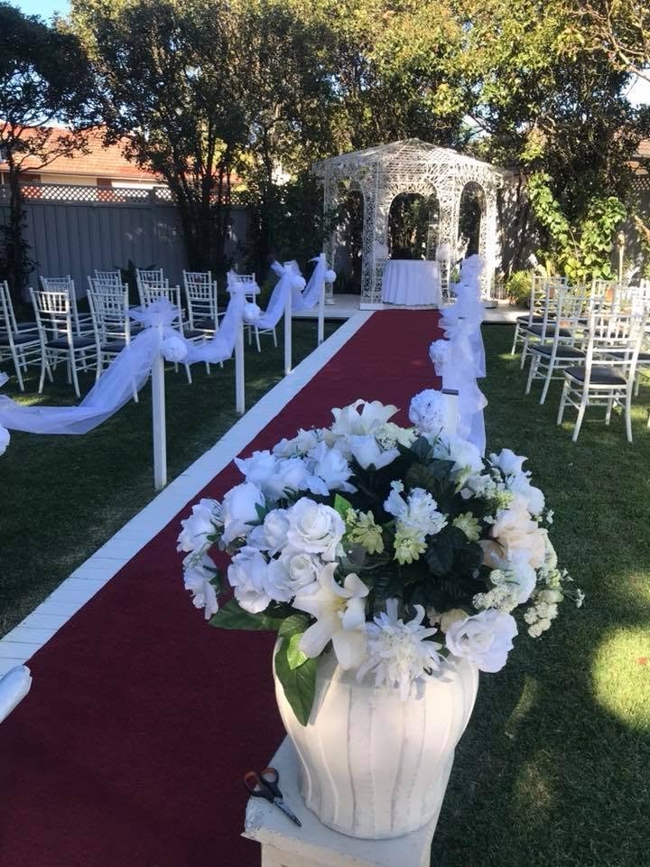 Outdoor wedding ceremony aisle with red carpet leading to the white gazebo